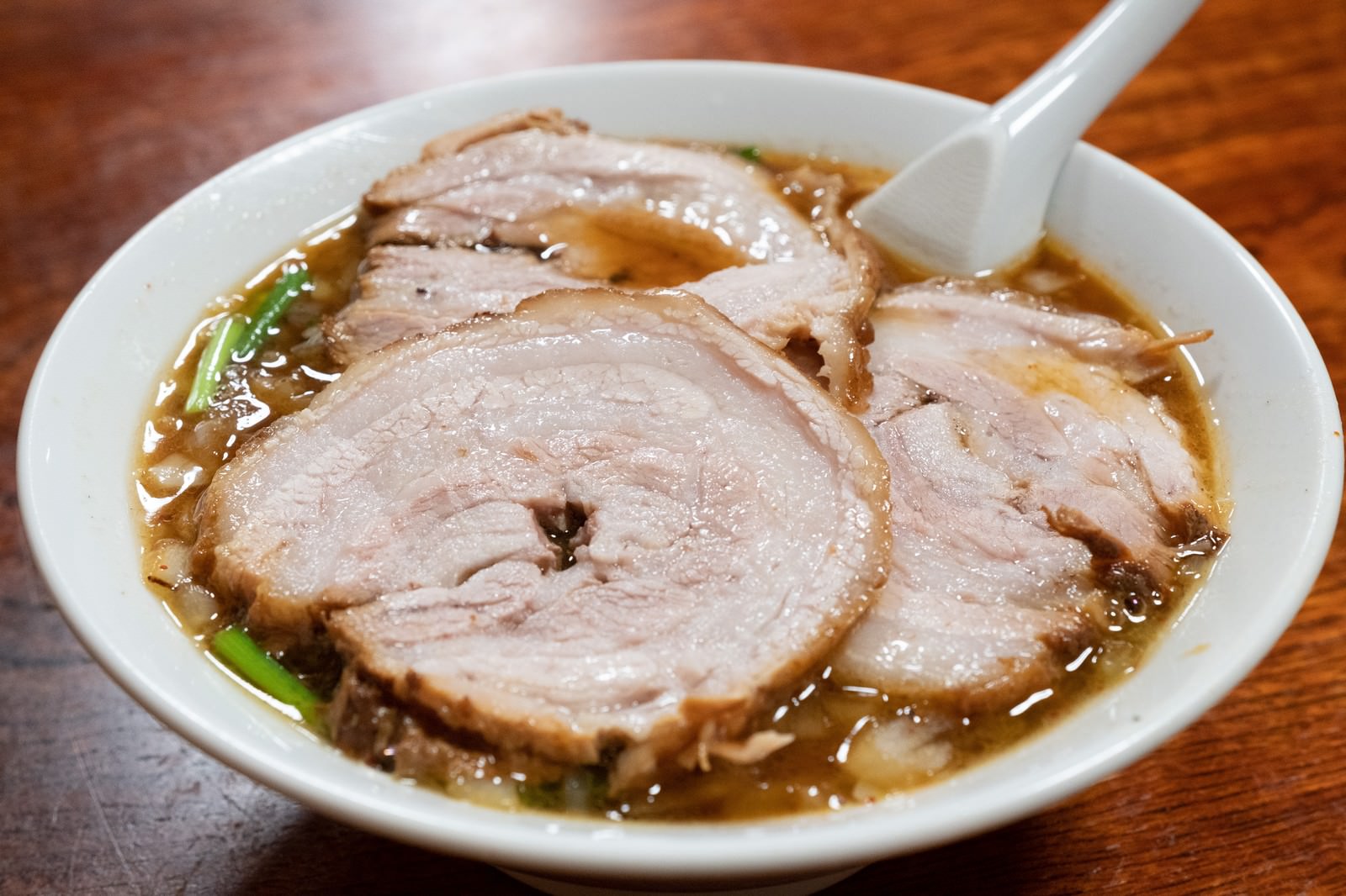 木のカウンターに置かれた一期一会 醤油チャーシュー麺